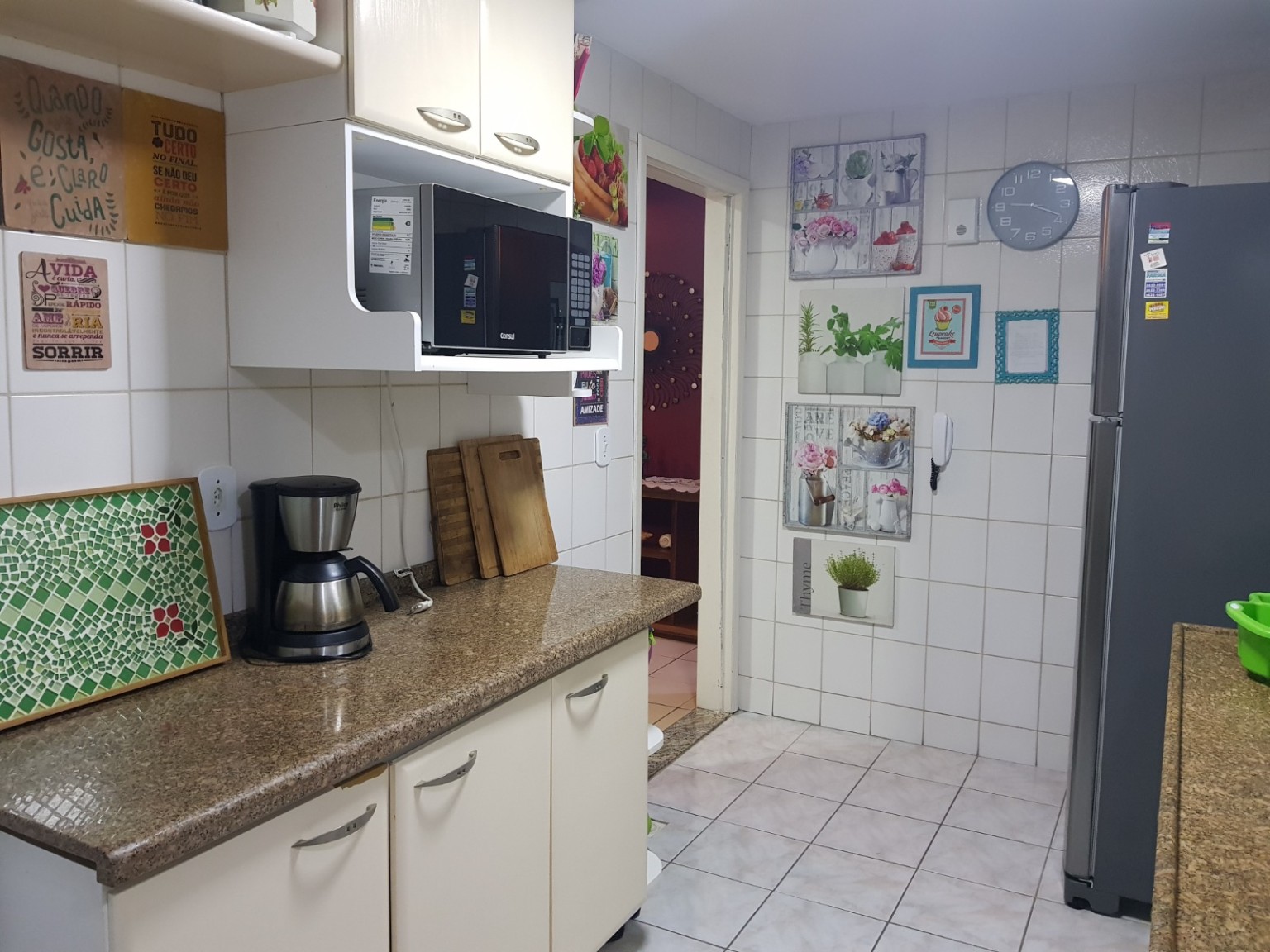 Cozinha com bancada, micro-ondas e cafeteira